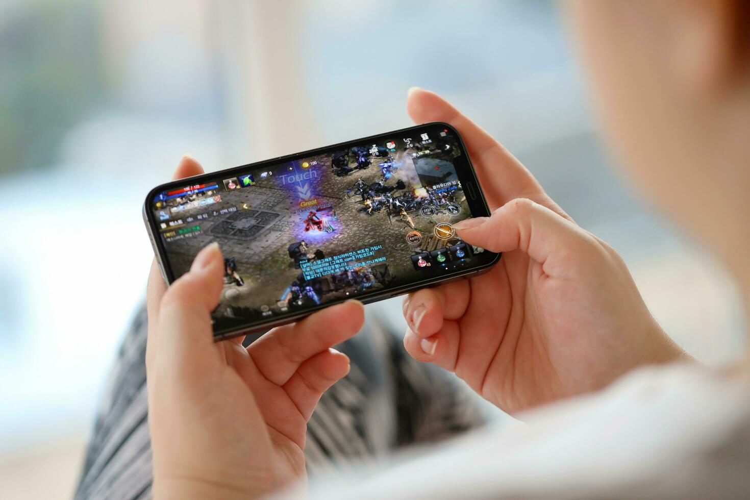 Mobile gaming demonstration shown on a primary smartphone screen featuring fictional gameplay graphics during a technology showcase